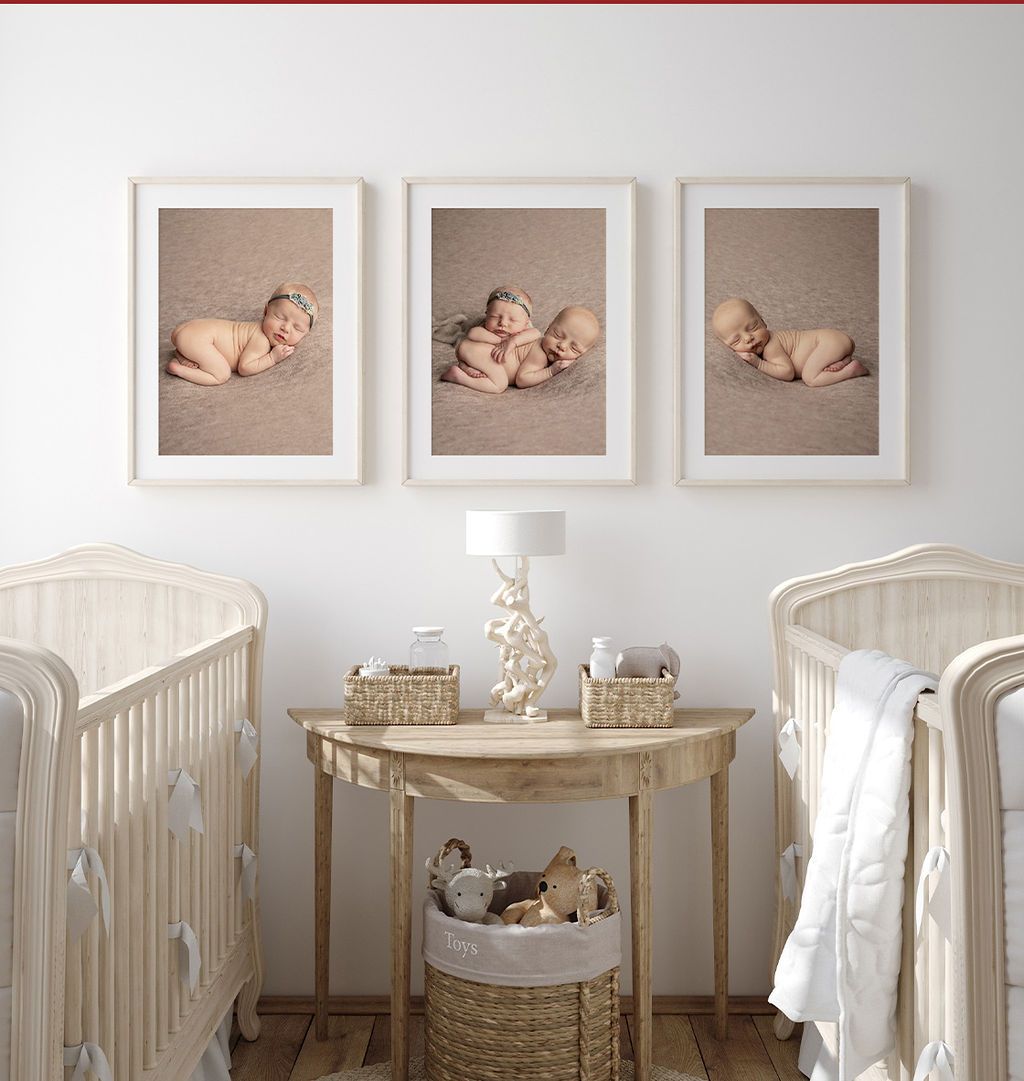 Three framed baby photos above a table with two cribs, neutral color nursery.