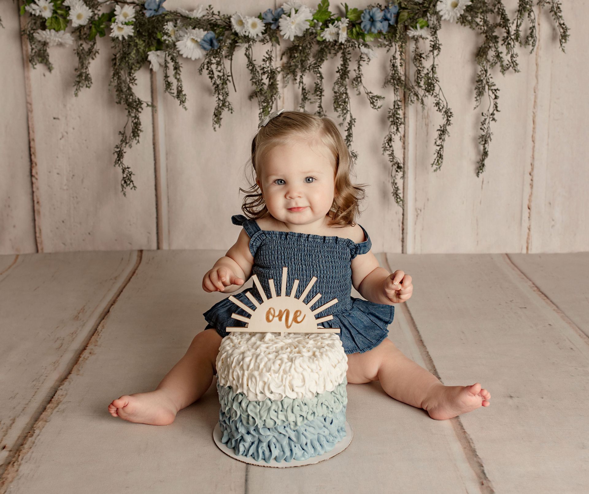 Child seated in front of a cake with a 