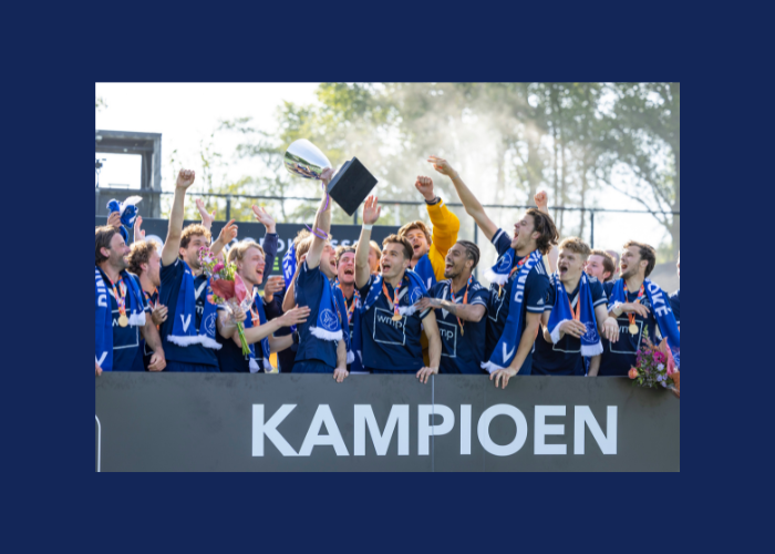 Het feestvierende team in blauwe shirts heft een trofee omhoog onder het woord