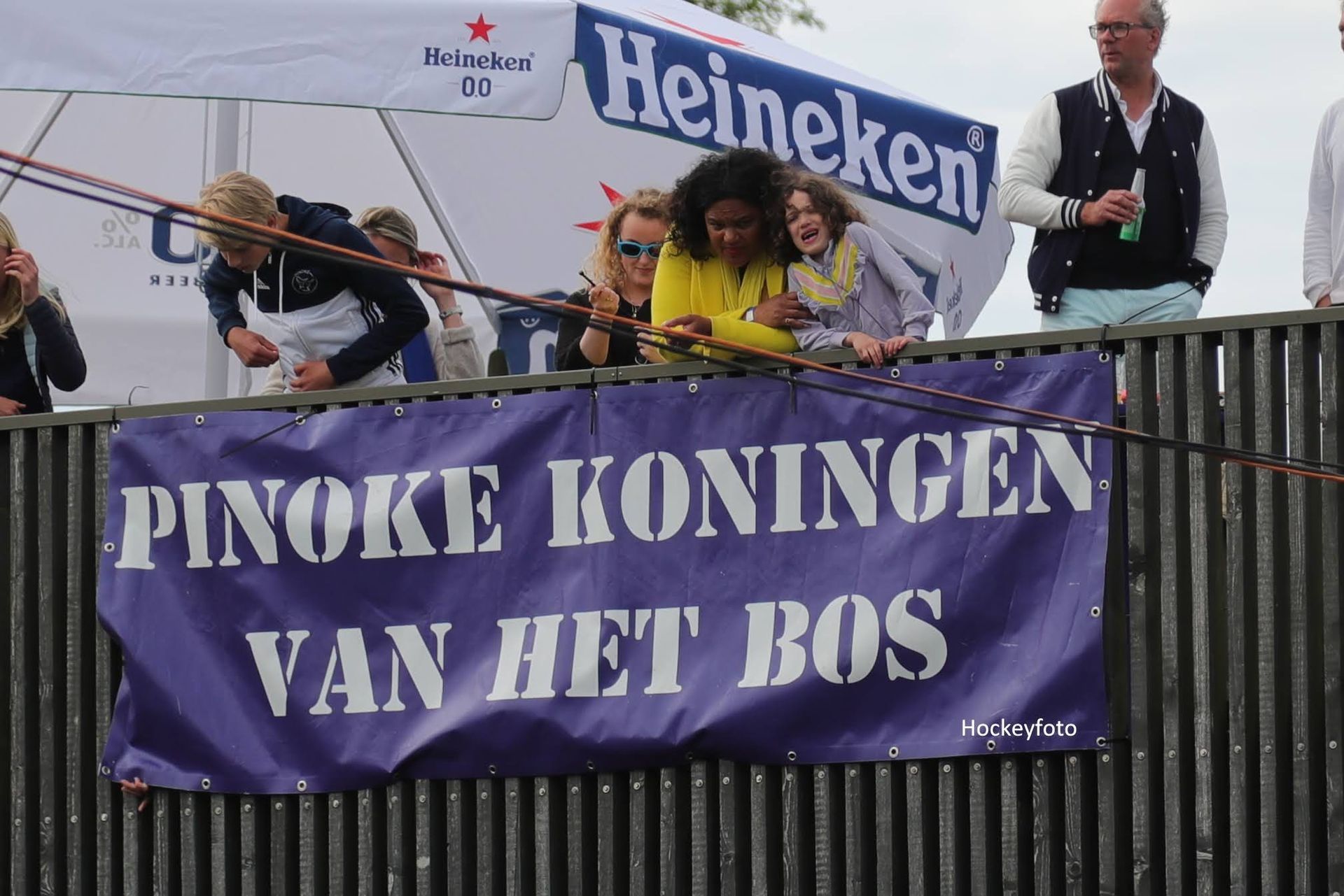 People on a float holding a banner reading “PINKIE KONINGEN VAN HET BOS” with a Heineken flag above