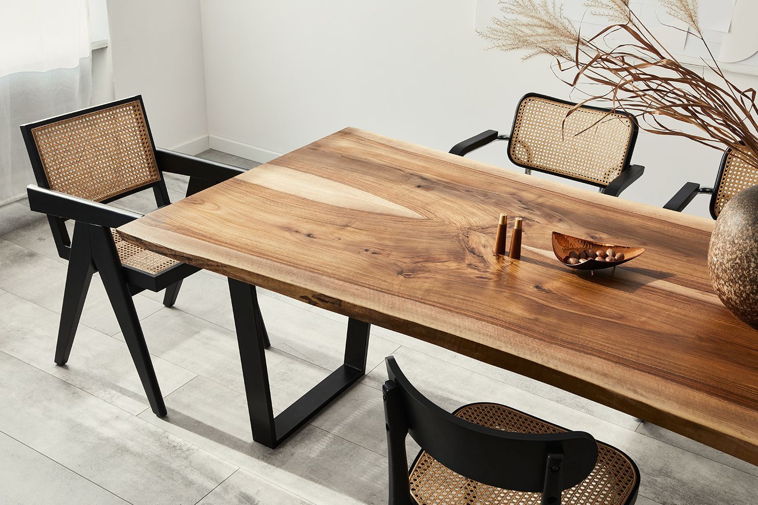 Wooden dining table with four chairs, neutral tones.