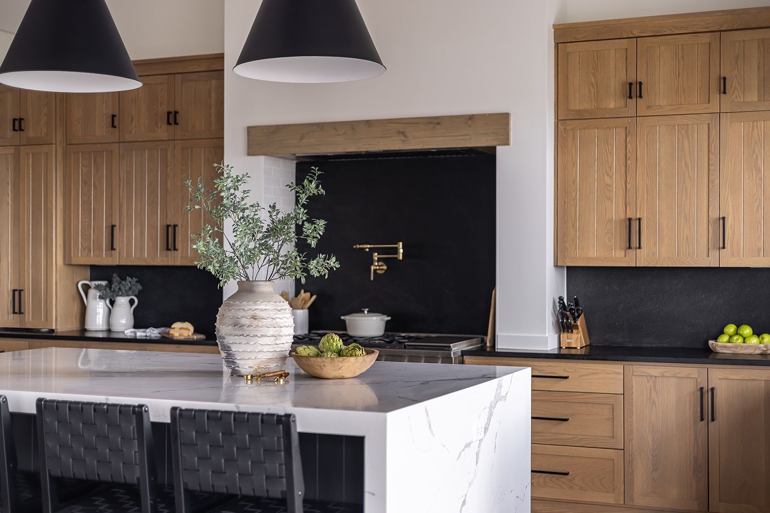 Modern kitchen with light wood cabinets, black accents, and a large island with seating. Modern kitchen with light wood cabinets, black accents, and a large island with seating.