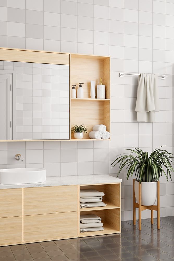 Modern bathroom with light wood cabinets, white sink, and tiled walls.