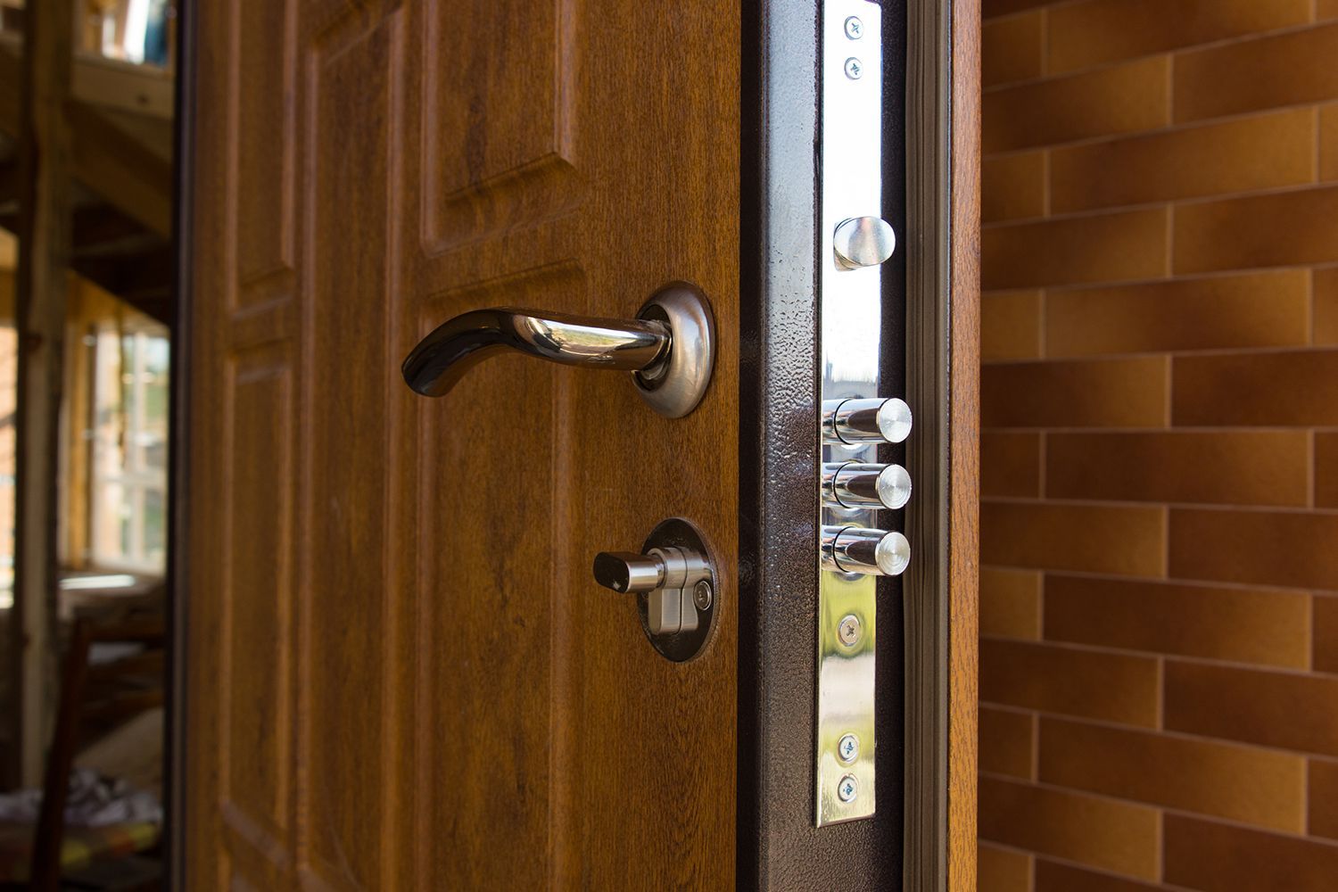 Open brown door with a metal security lock on a brick wall. Open brown door with a metal security lock on a brick wall.