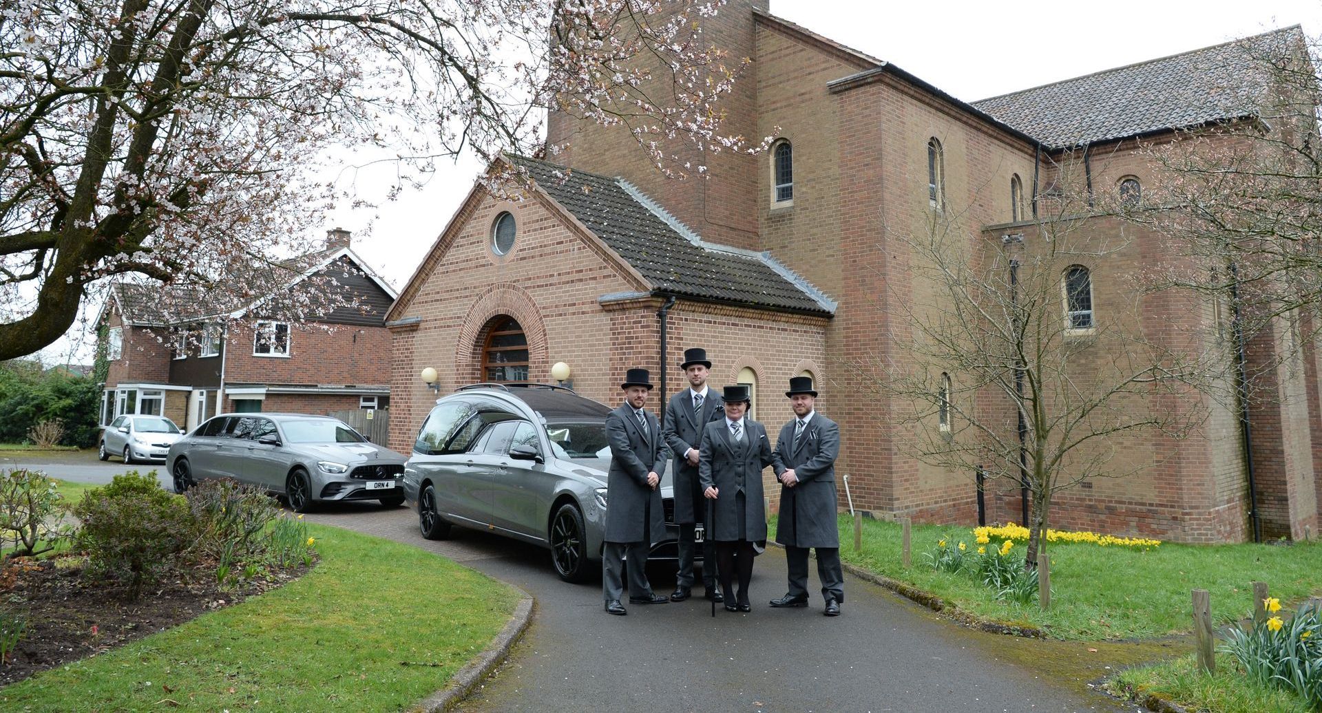 funeral directors in front of the church