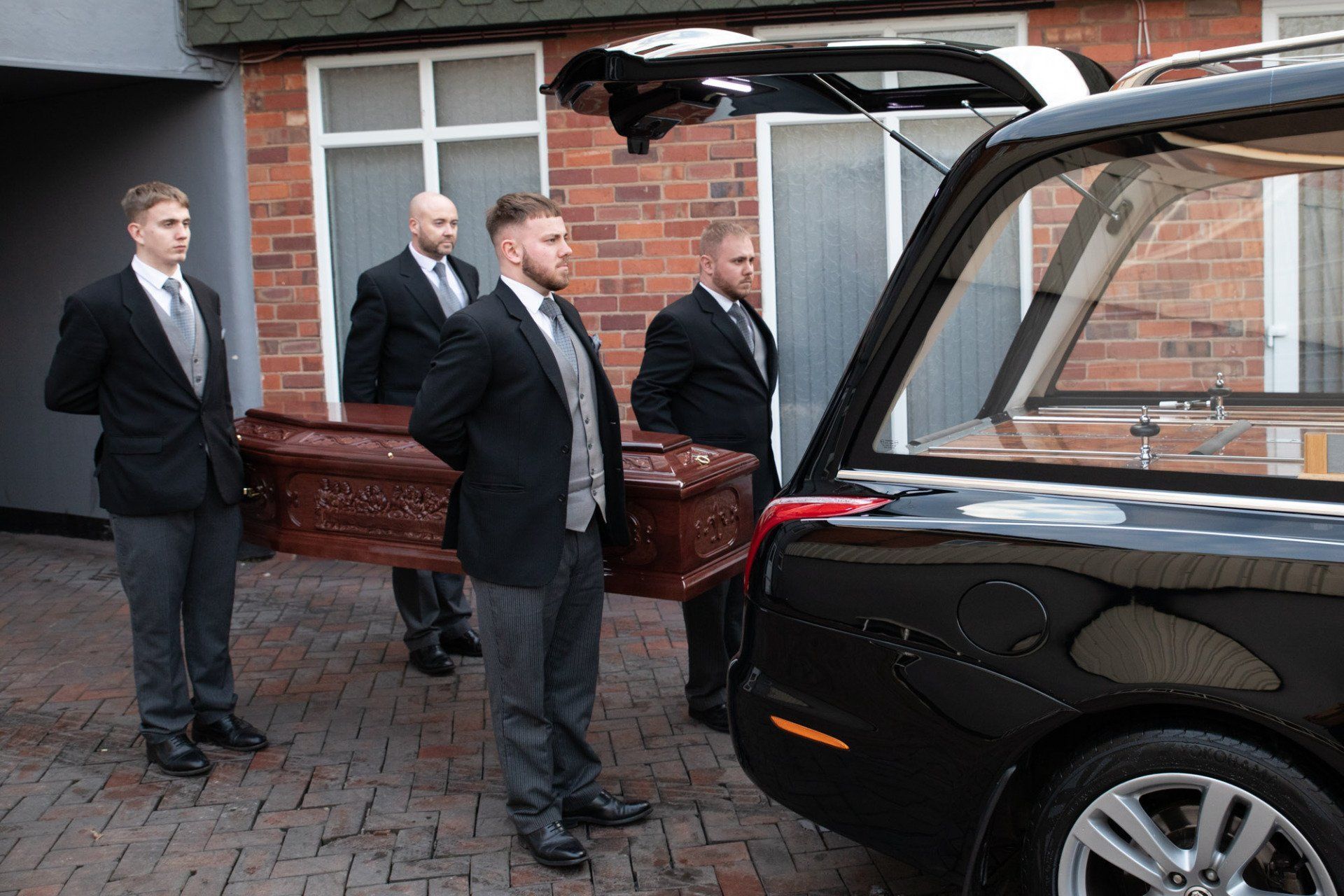 pallbearers caring the coffin to the hearse