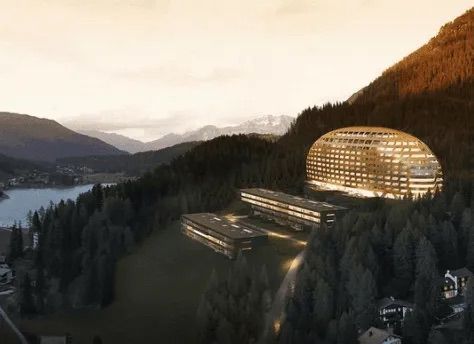 Auf einem Berggipfel neben einem See steht ein großes Gebäude.