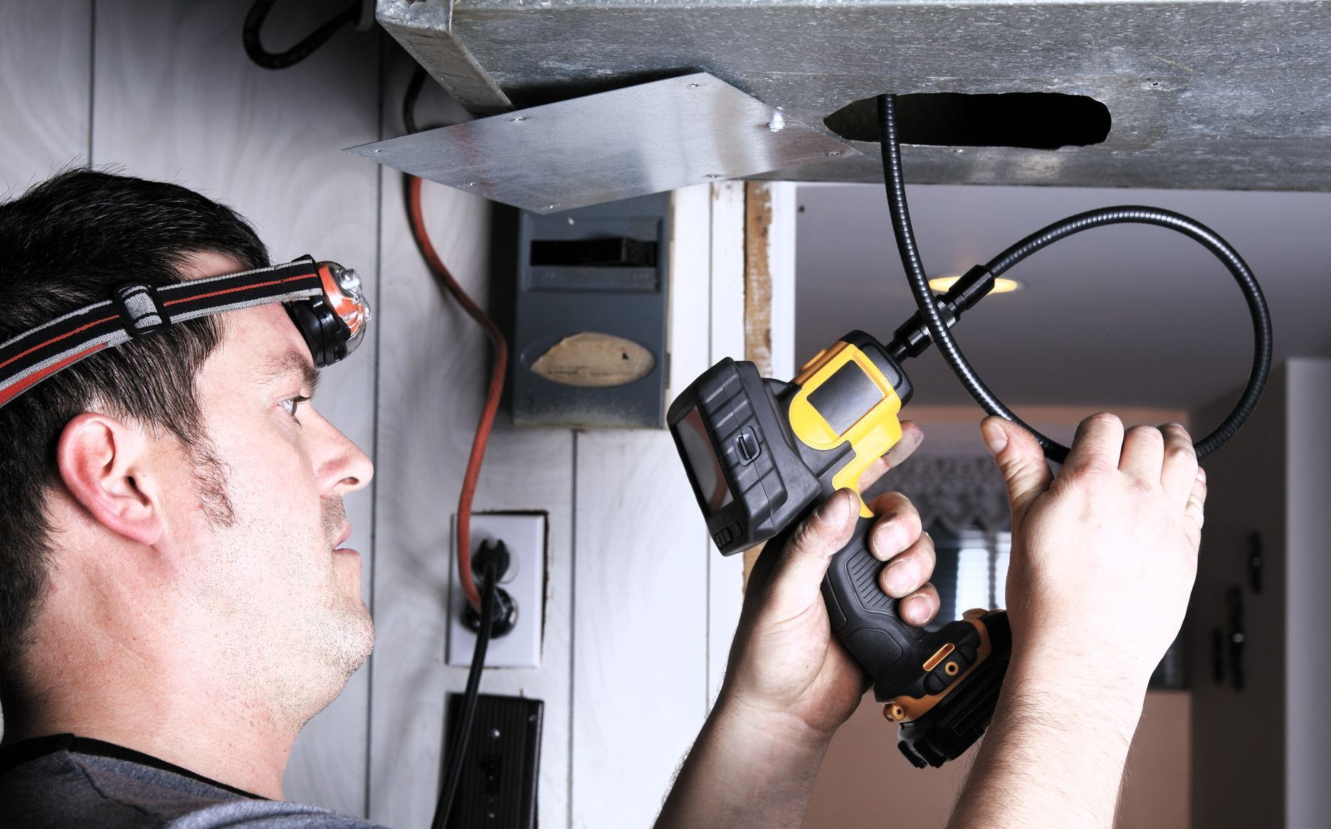 Skilled technician using air duct cleaning tool for ventilation maintenance.