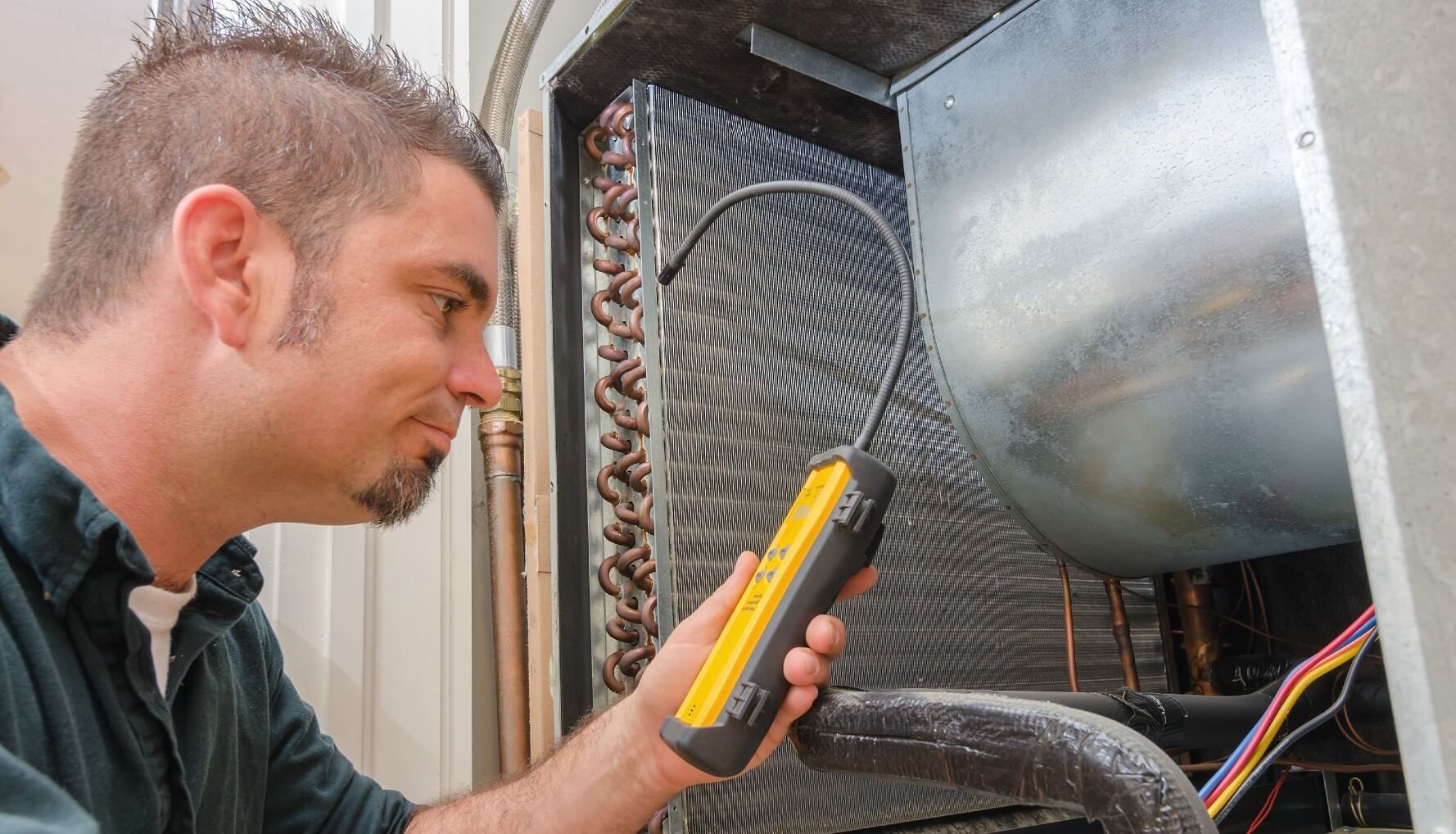 Technician checking for air leaks to prepare for the summer