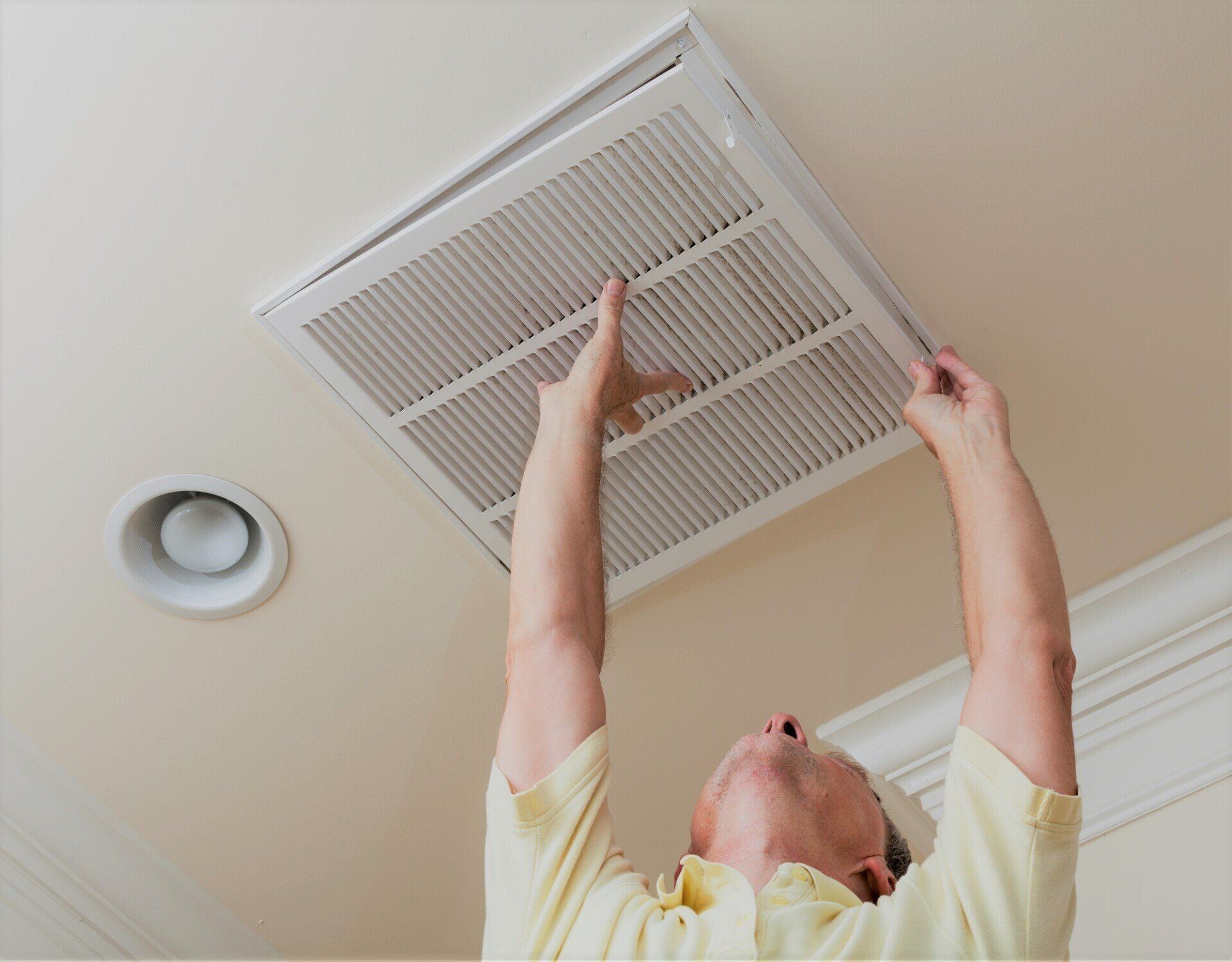 a man changing a dirty duct filter