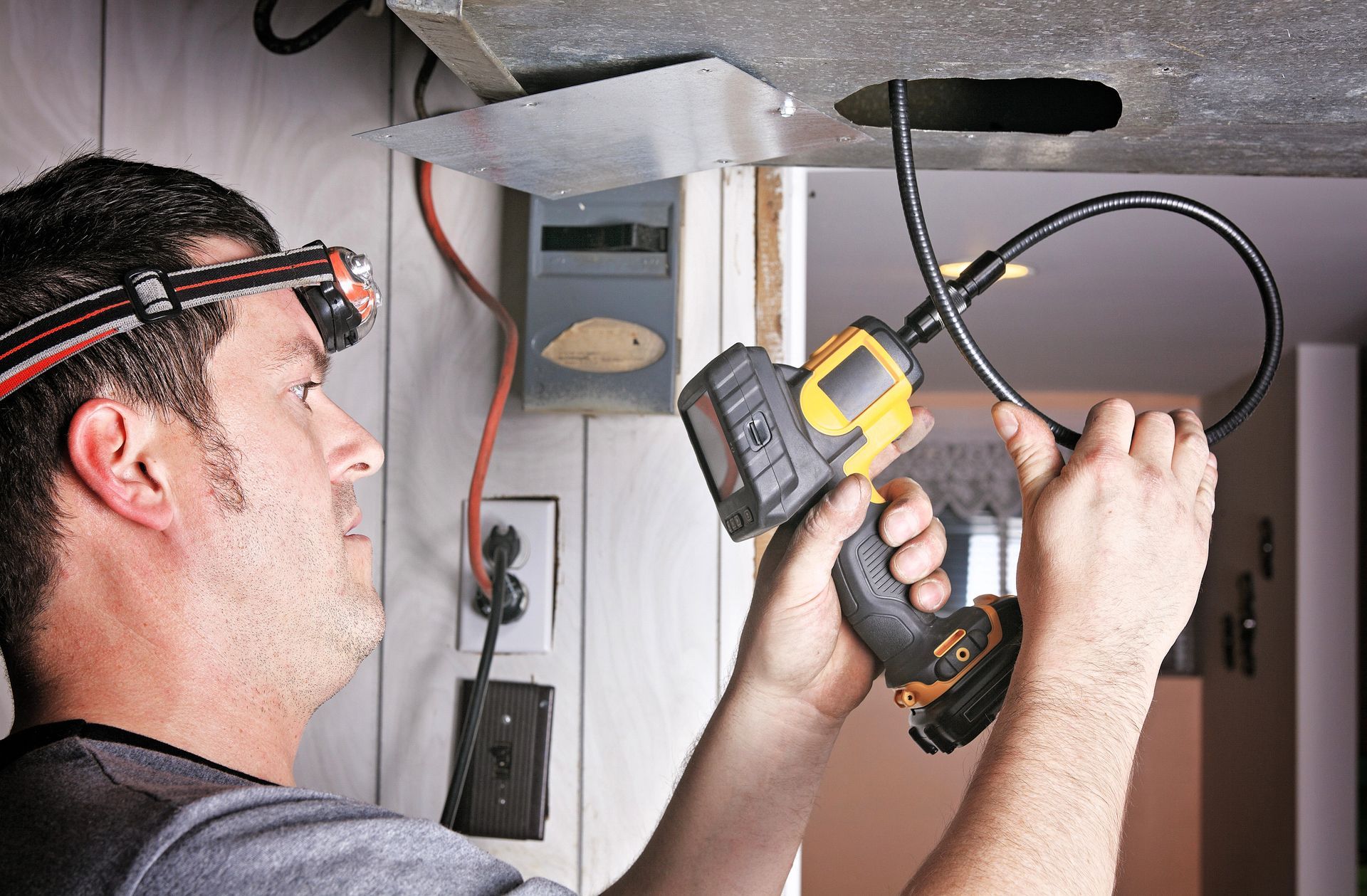 Technician performing duct inspection using a device to check HVAC system for leaks and debris