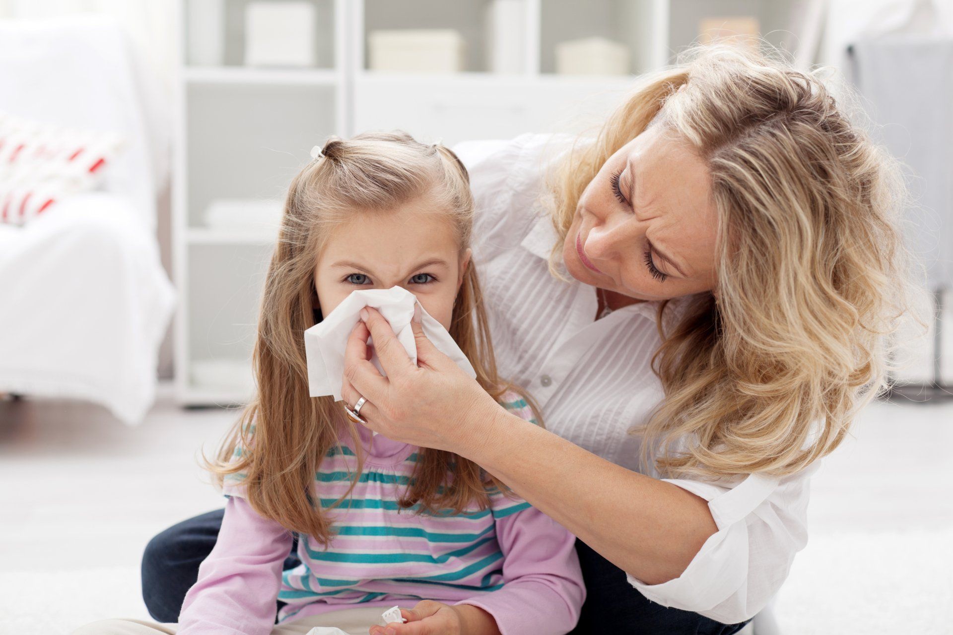 mother holds tissue for child who has allergies due to mold exposure