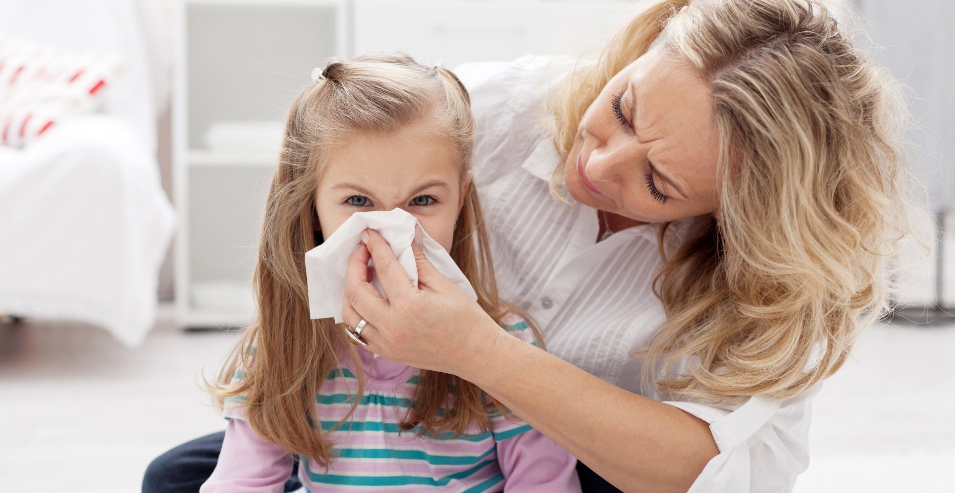 mother tends to child sneezing from mold in the home