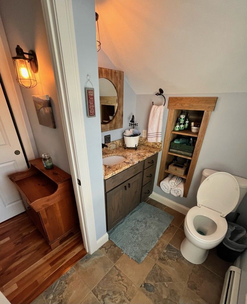 A bathroom with a toilet a sink and a mirror