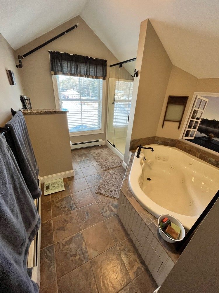 A bathroom with a jacuzzi tub and a walk in shower.