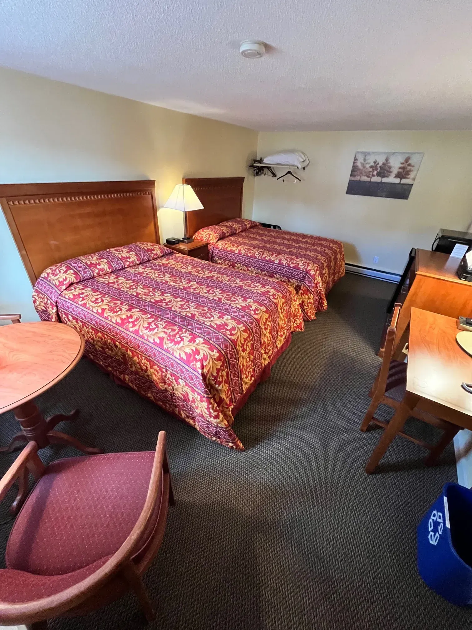 A hotel room with two beds , a table and chairs.