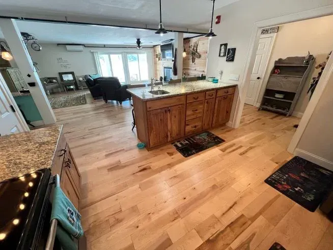 A kitchen with hardwood floors and a large island in the middle.