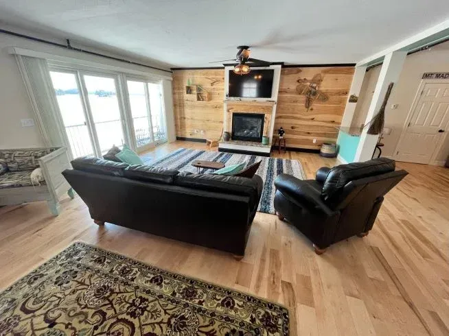 A living room with a couch , chairs and a fireplace.