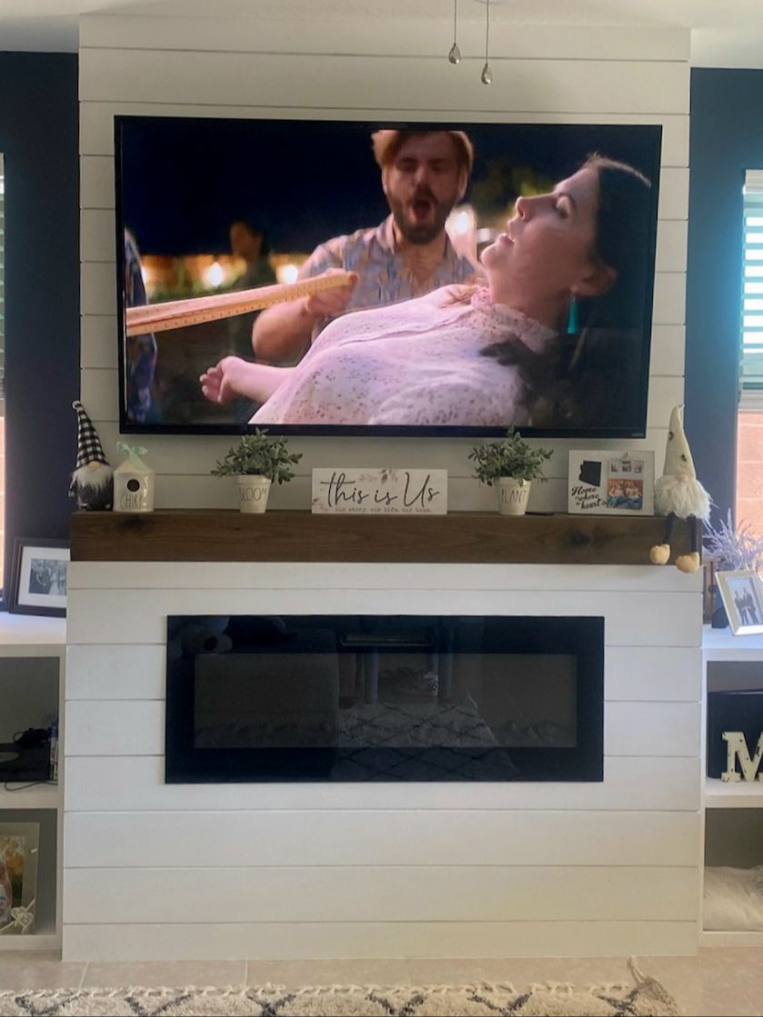A living room with a fireplace and a flat screen tv.