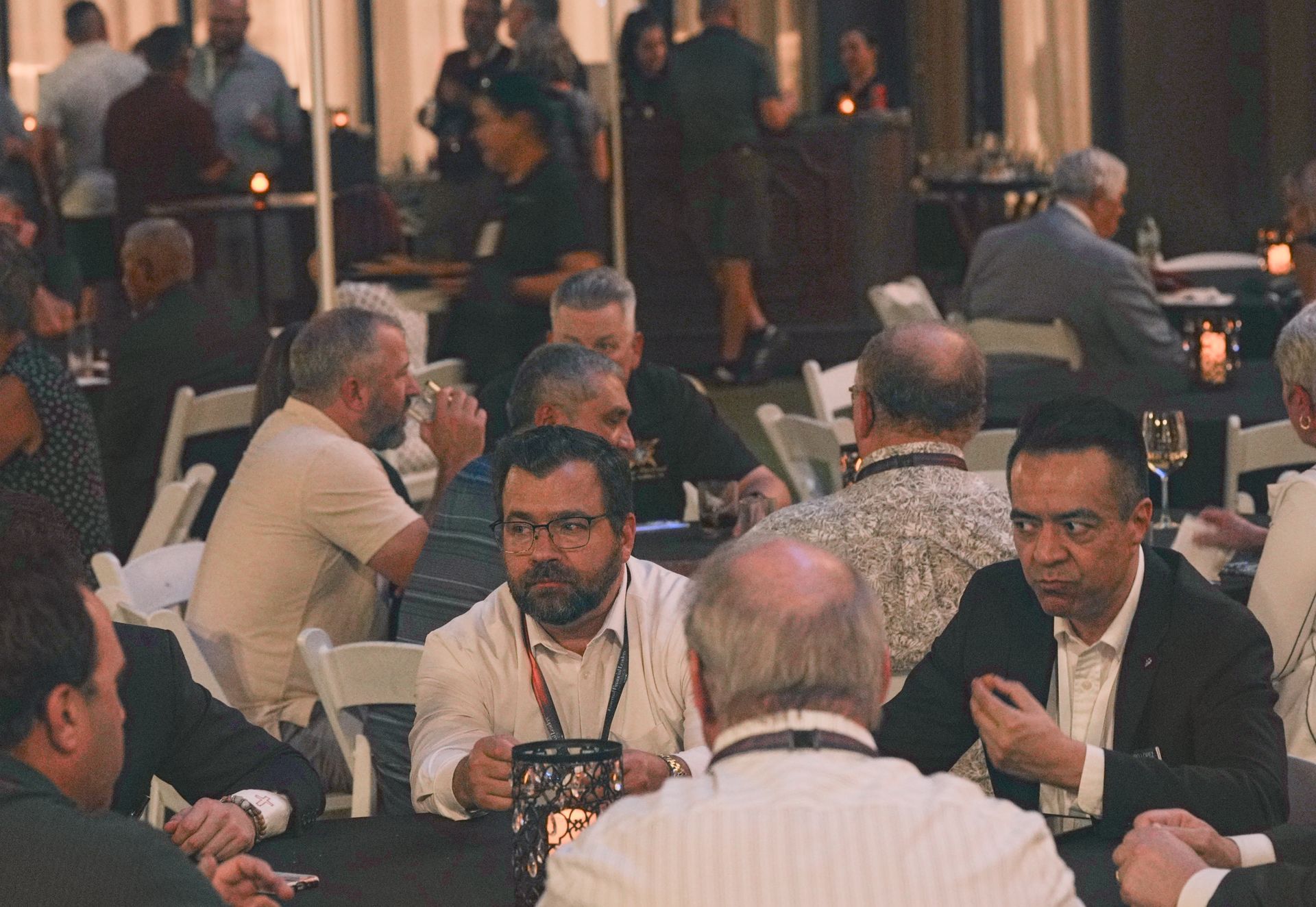 Conference attendees sharing conversation around reception tables