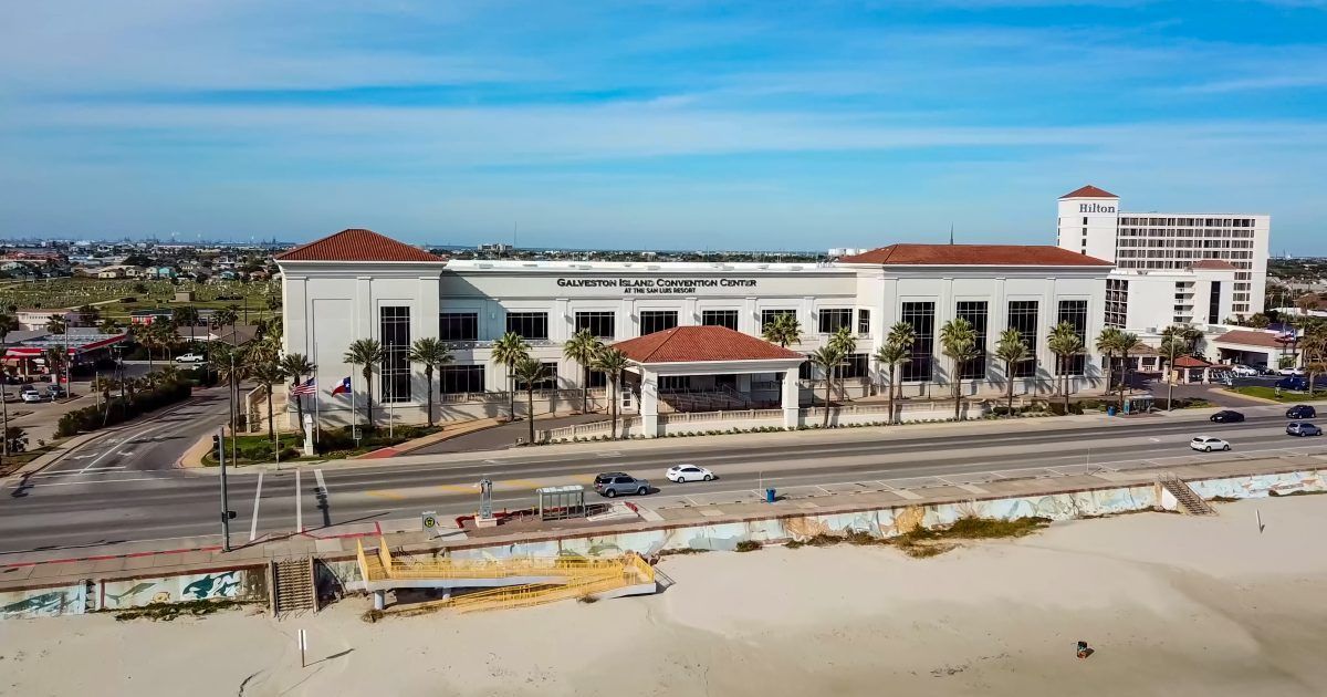 Galveston Island Convention Center beside Seawall Boulevard, with the beach in front and Hilton next door