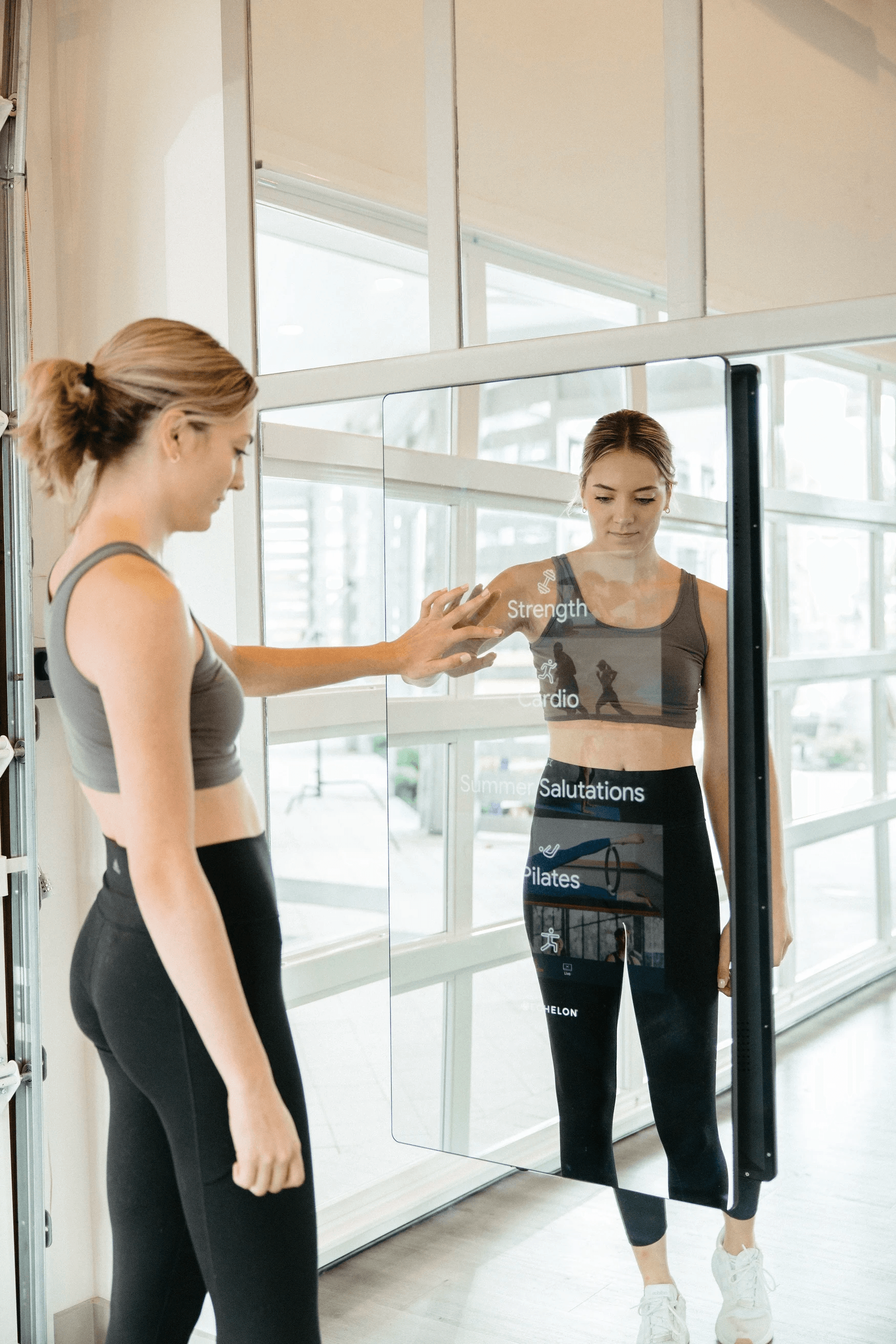 A woman is looking at her reflection in a mirror.
