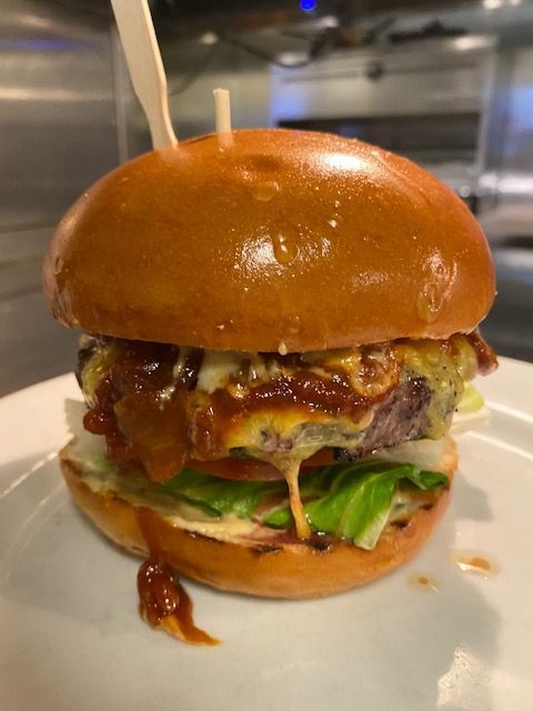 A close up of a hamburger on a white plate.