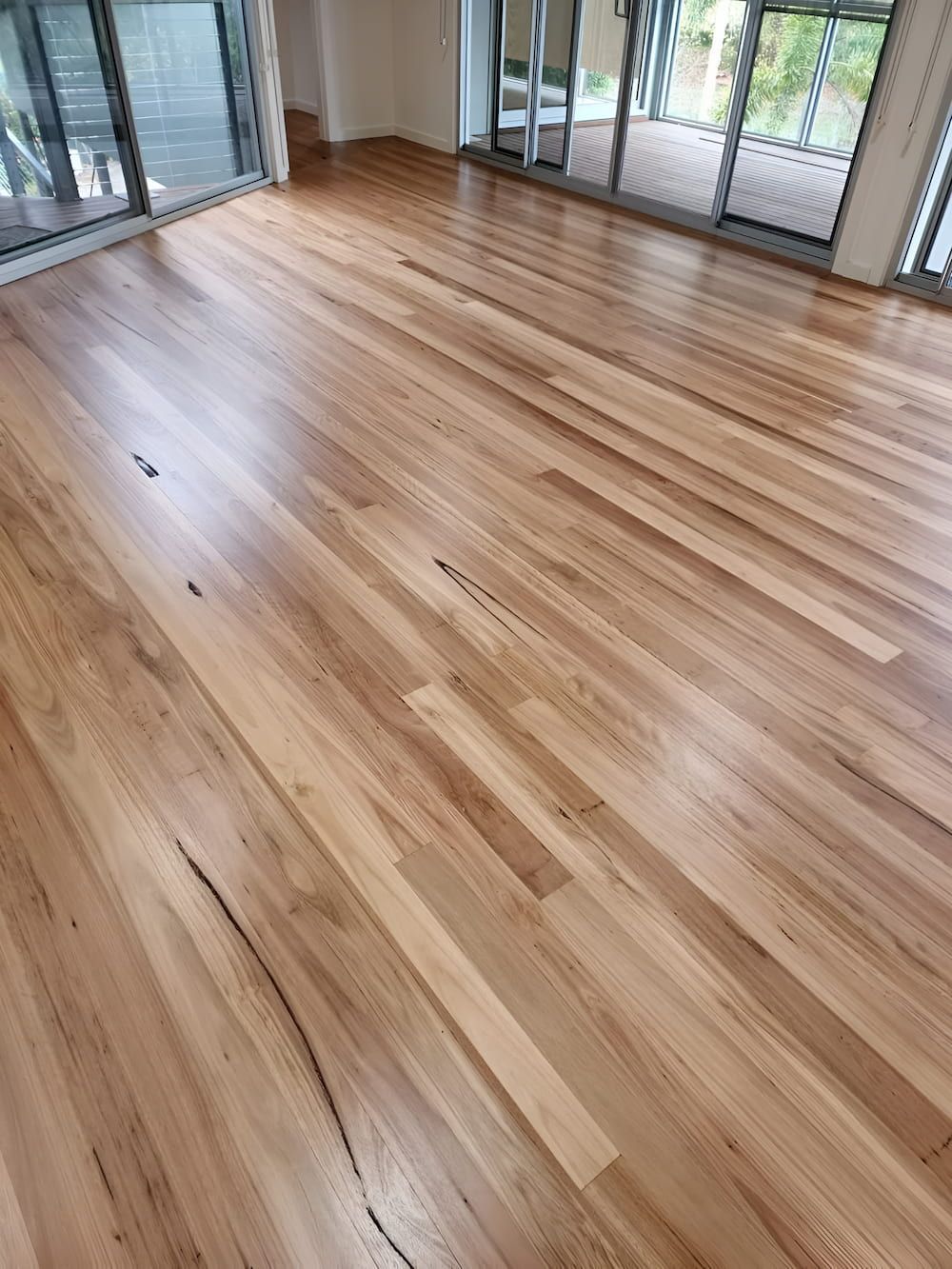 A Living Room With Hardwood Floors And Sliding Glass Doors — Kyall Chalker Floor Sanding & Polishing In North Haven, NSW