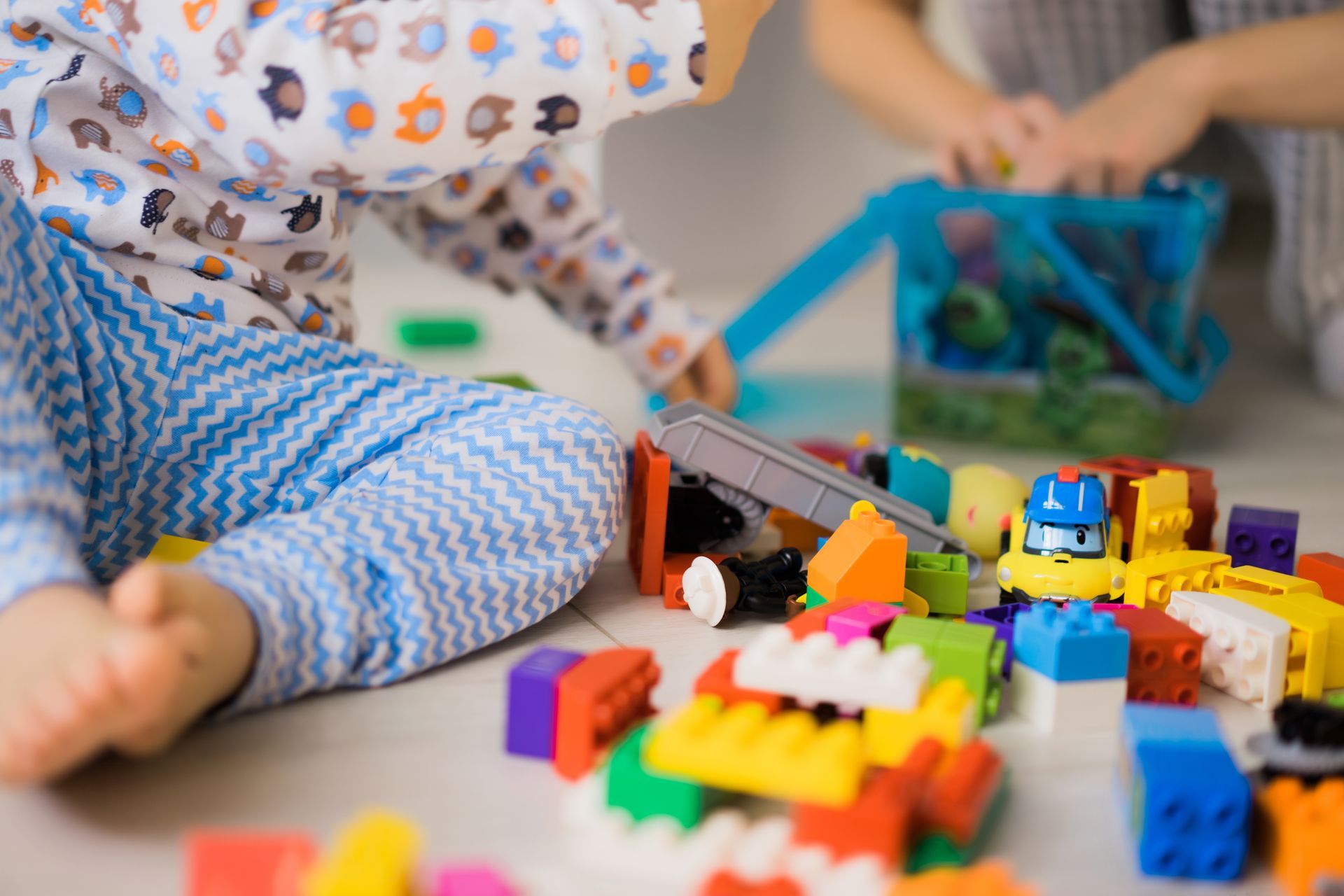 Children playing with colorful toy blocks and cars on the floor