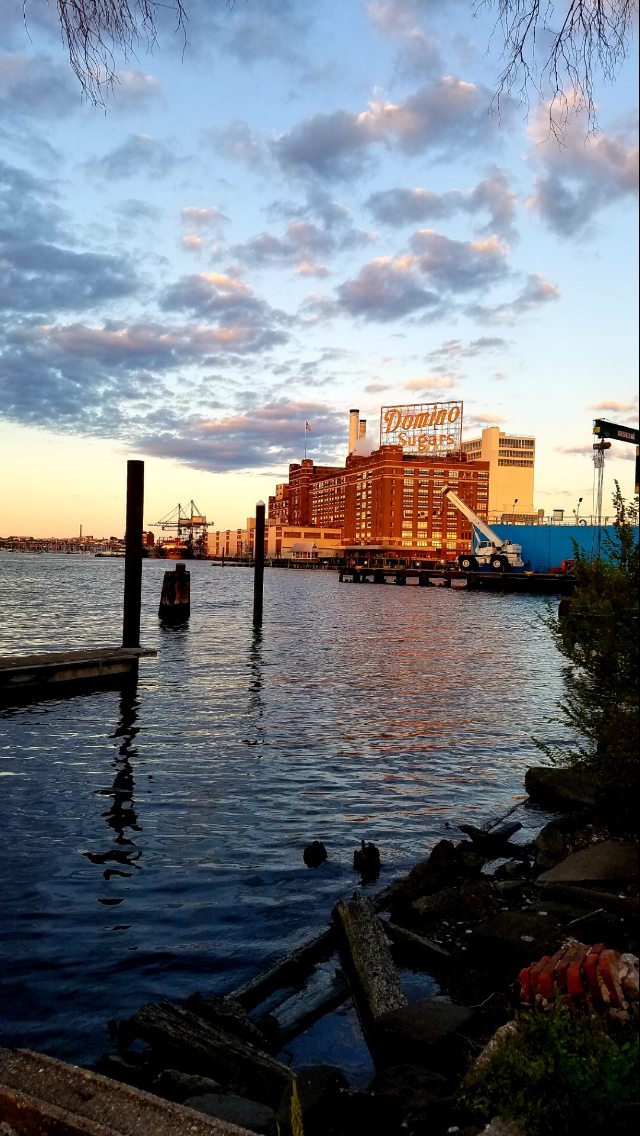 A large building is sitting on the shore of a body of water.