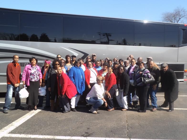 A white bus is driving down a highway.