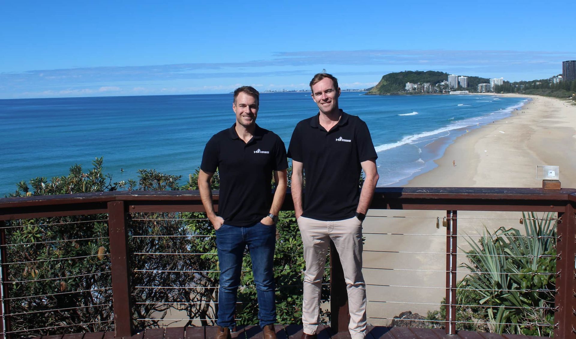 A man and a woman are standing next to each other covering their faces with their hands.