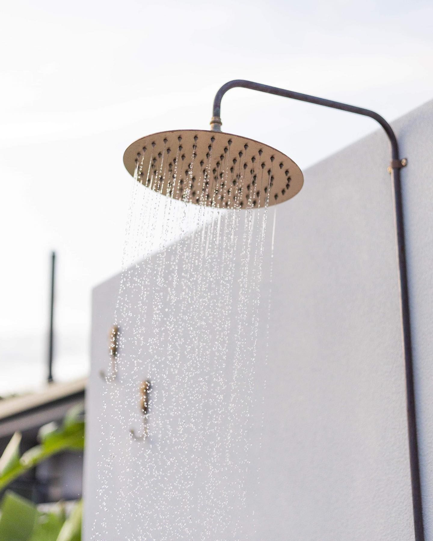 An outdoor shower head with water coming out