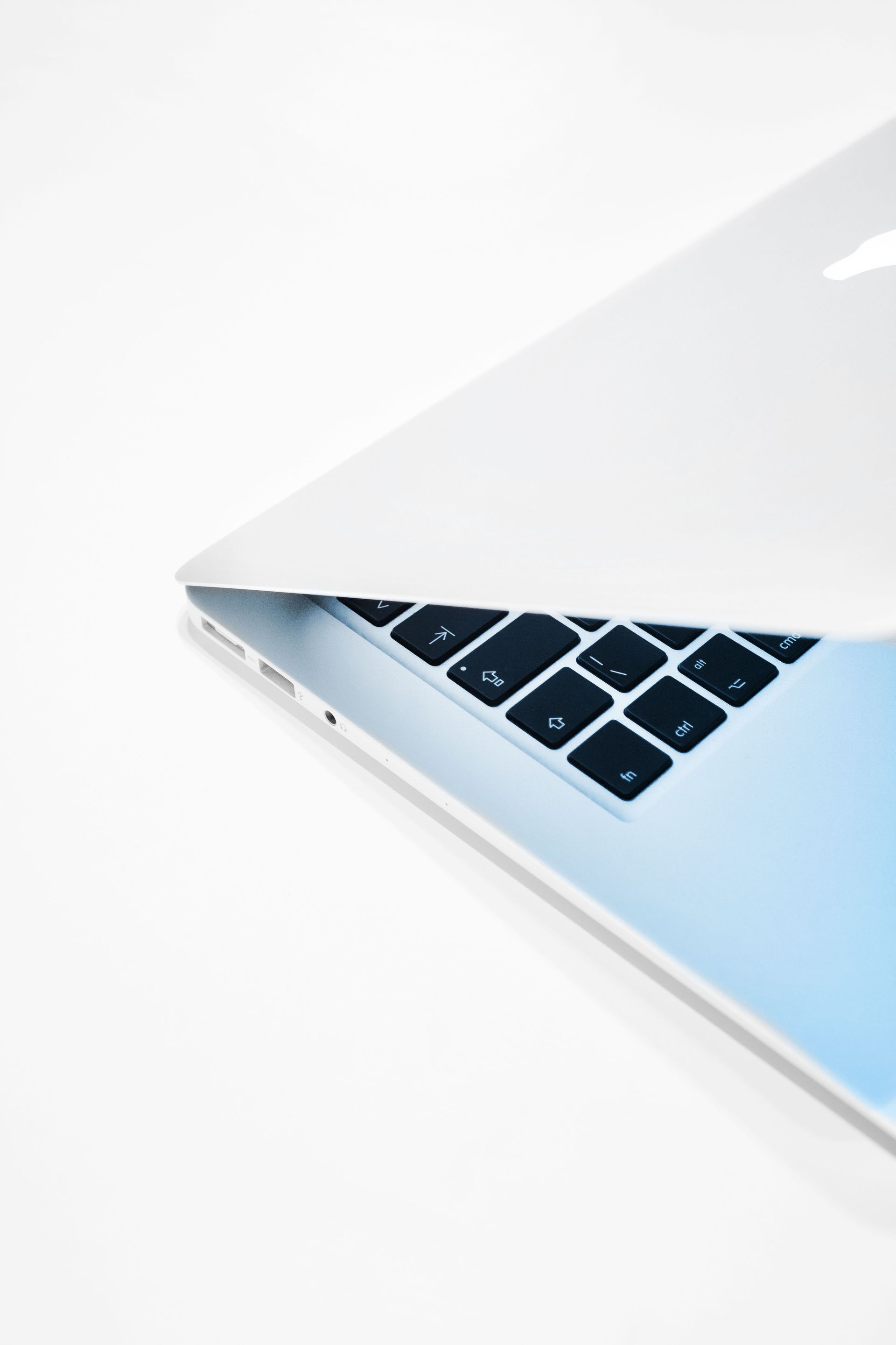 Open laptop with silver edge and black keyboard on a white background