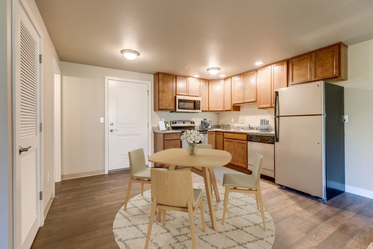 a kitchen with a table and chairs and a refrigerator .