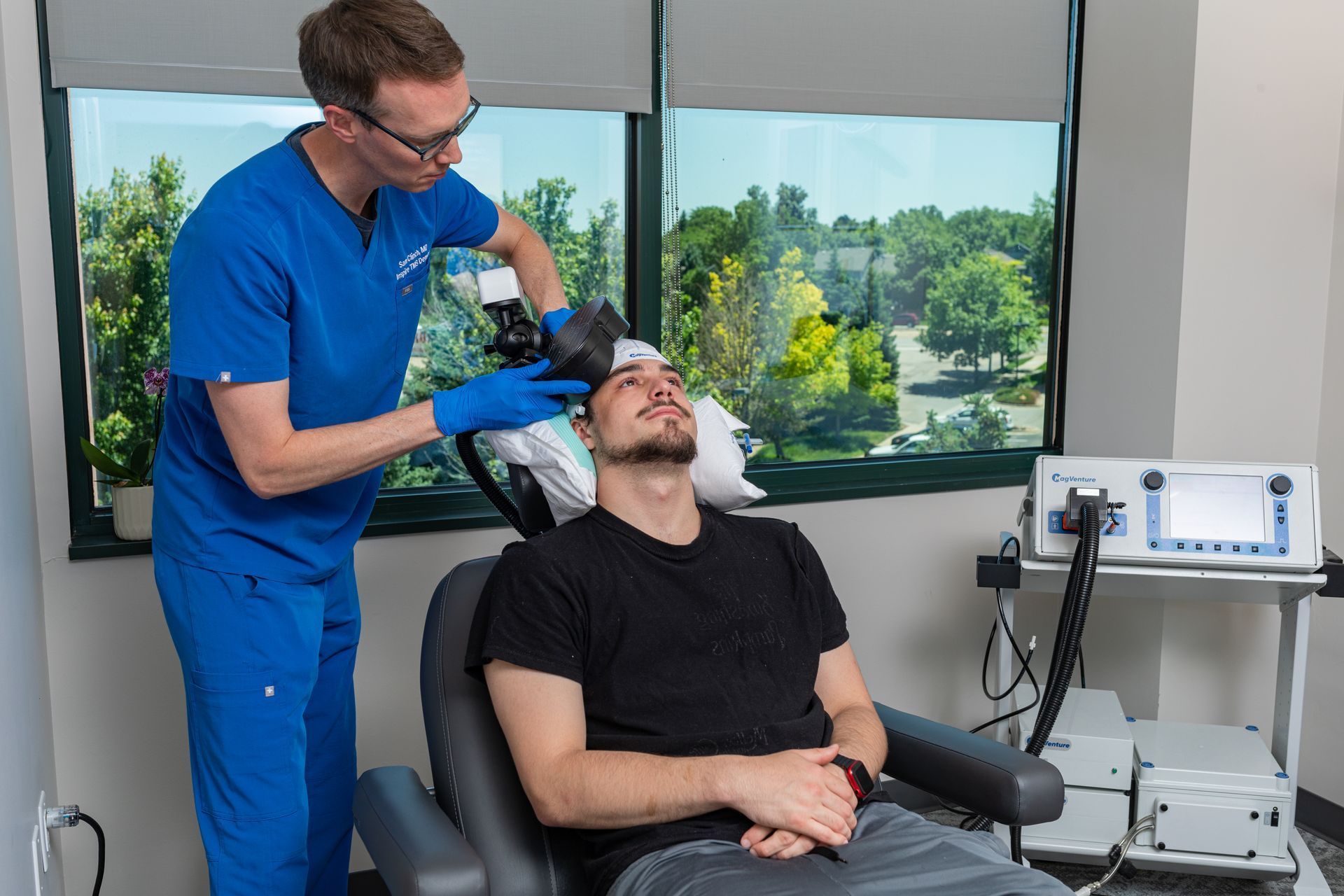 Dental professional examining a patient reclining in a chair with medical equipment nearby