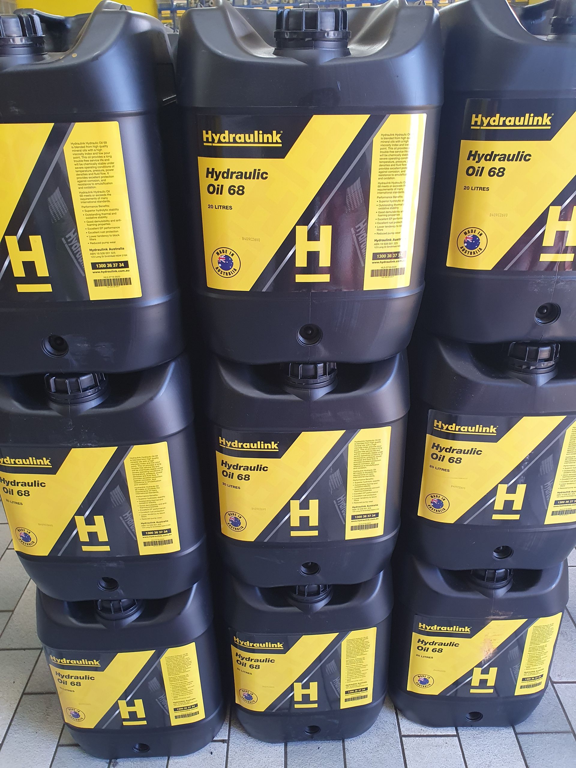 Stacked black and yellow chemical containers on store shelves with Hazard warning labels