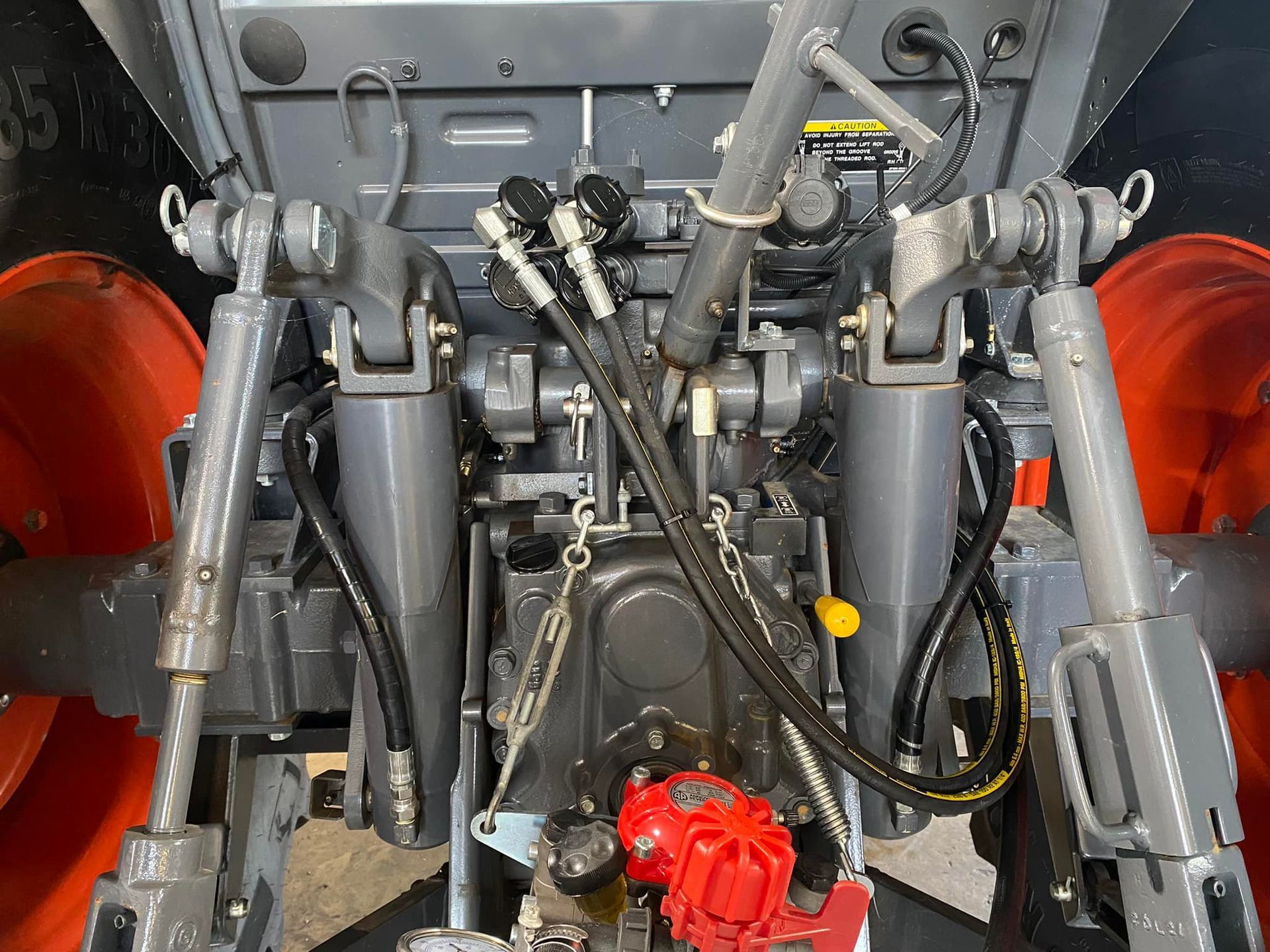 Close-up of a vehicle engine bay with gray and black mechanical parts and red components on the sides