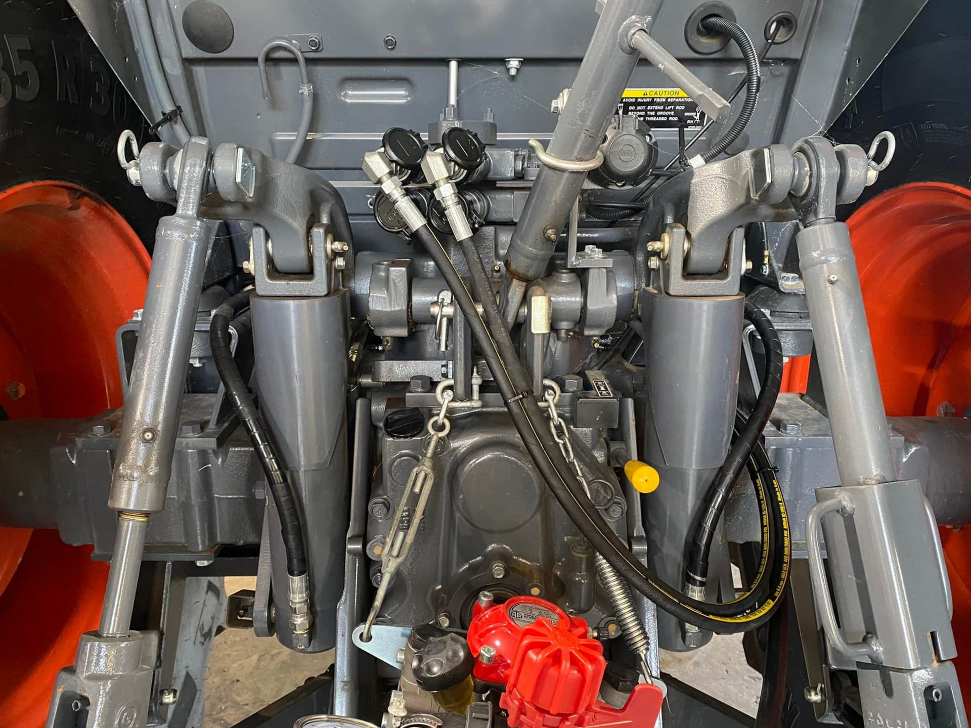 Close-up of a vehicle engine bay with gray and black mechanical parts and red components on the sides