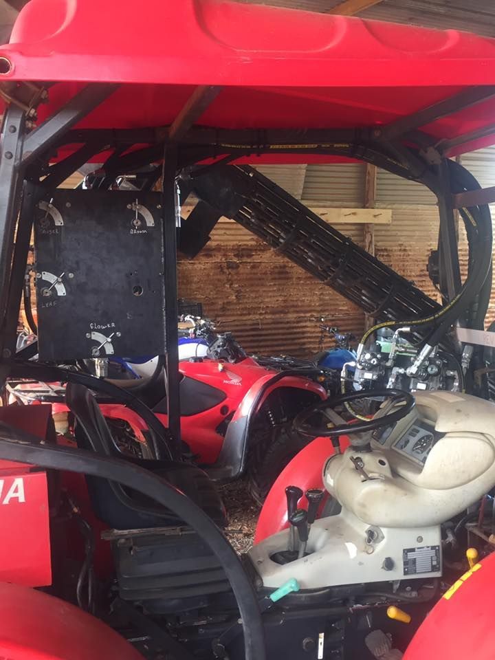 Red race car cockpit with roll cage and exposed engine components under the hood