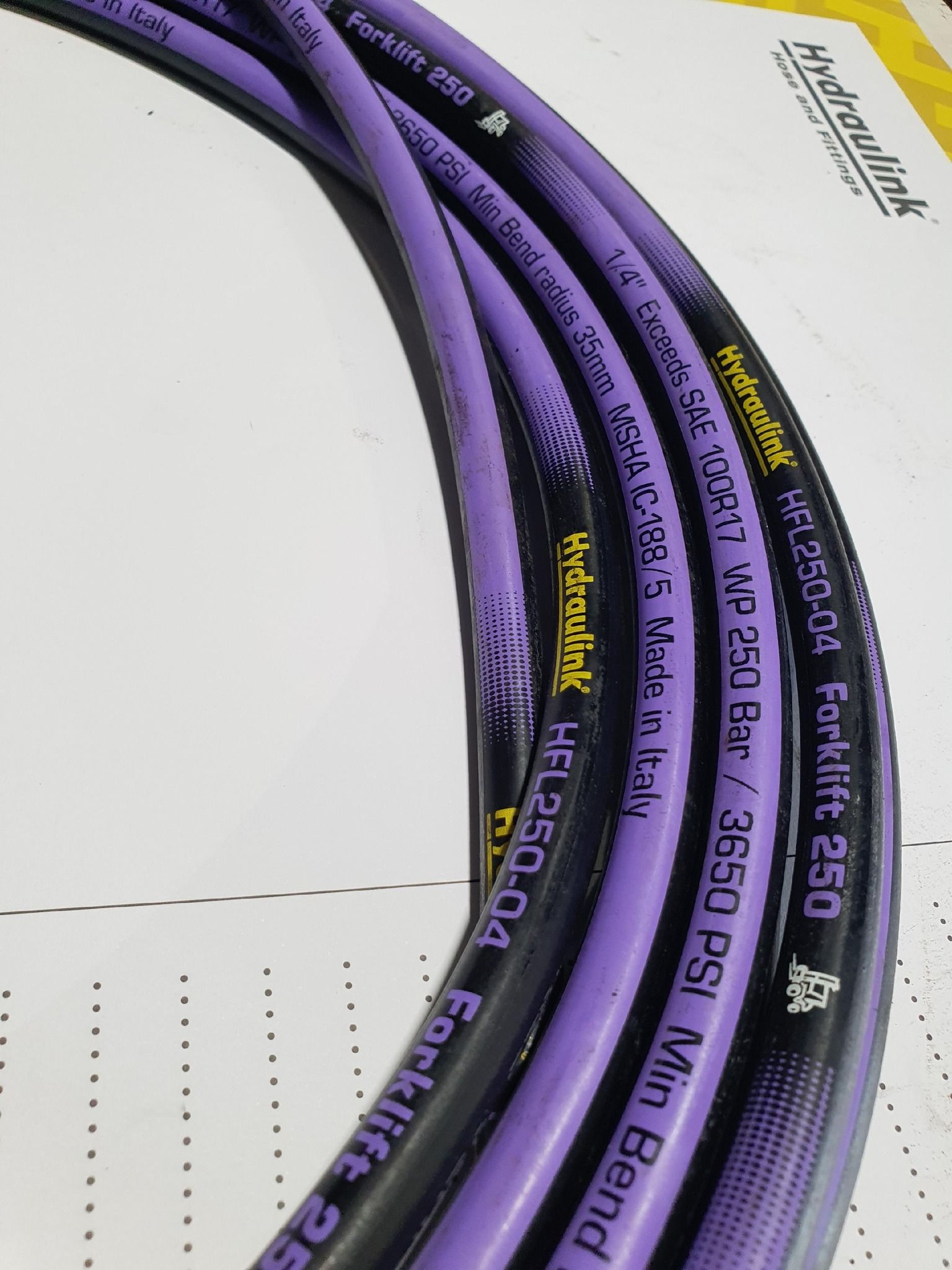 Purple network cables coiled on a white surface, labeled with text and numbers.