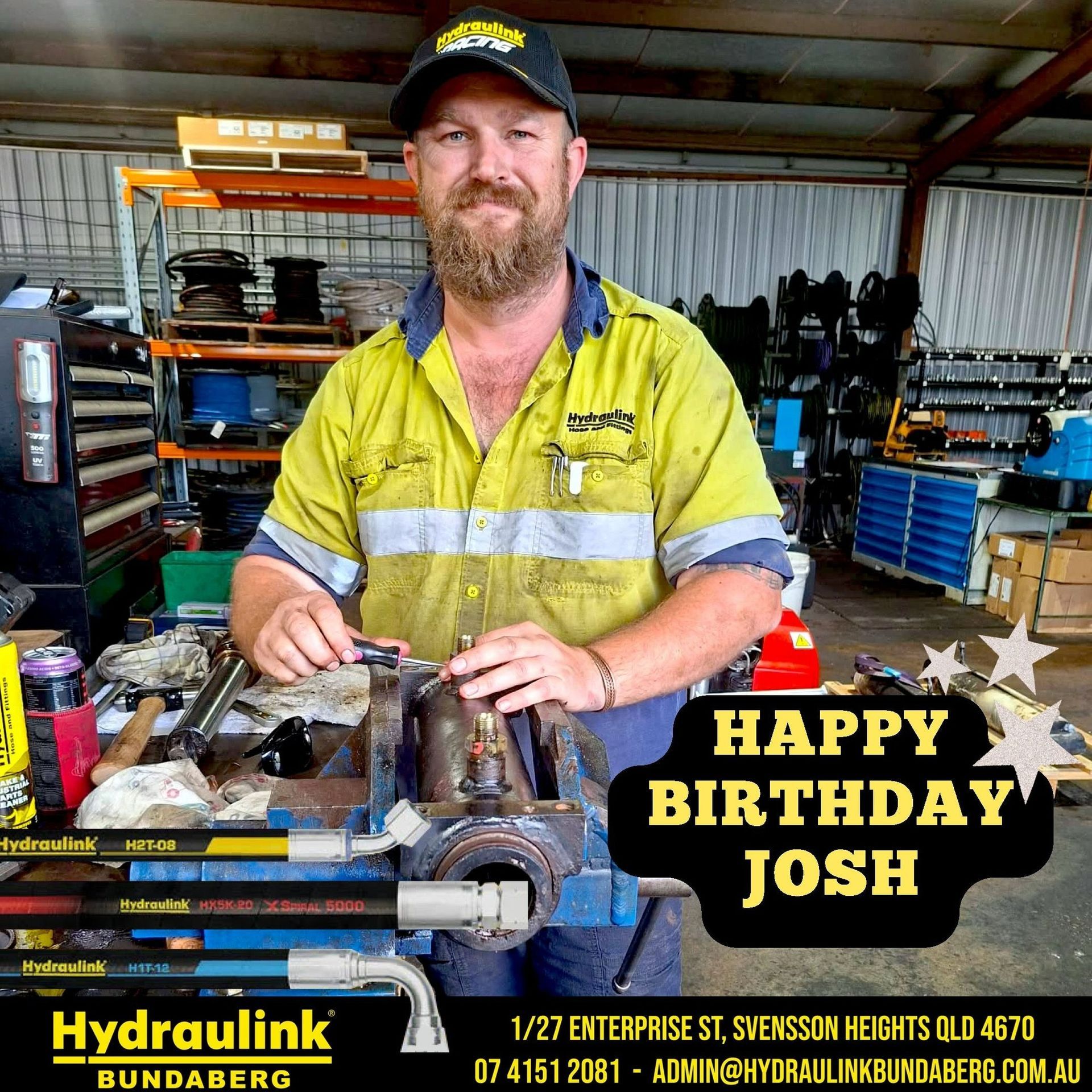Birthday banner for Josh in a workshop, with a man in a yellow shirt standing behind a metal machine