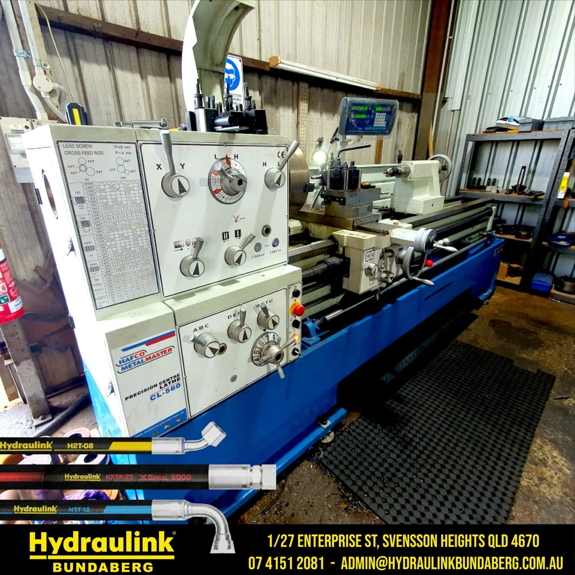 Hydraulik lathe in a workshop, with white control panels and blue base machinery.