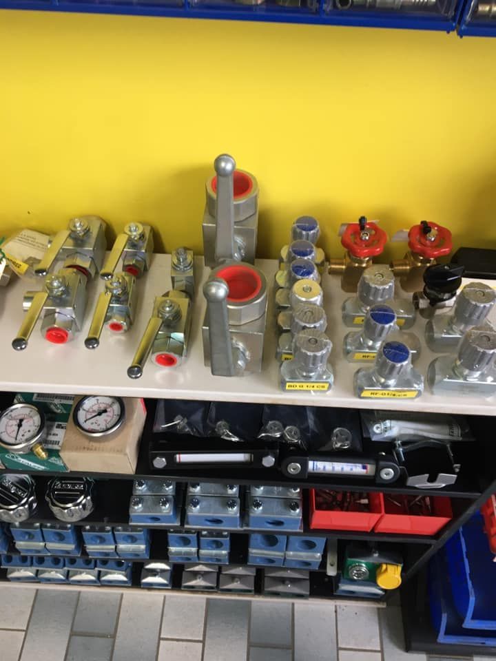 Shelves of assorted mechanical parts, valves, and fittings arranged on a shop display