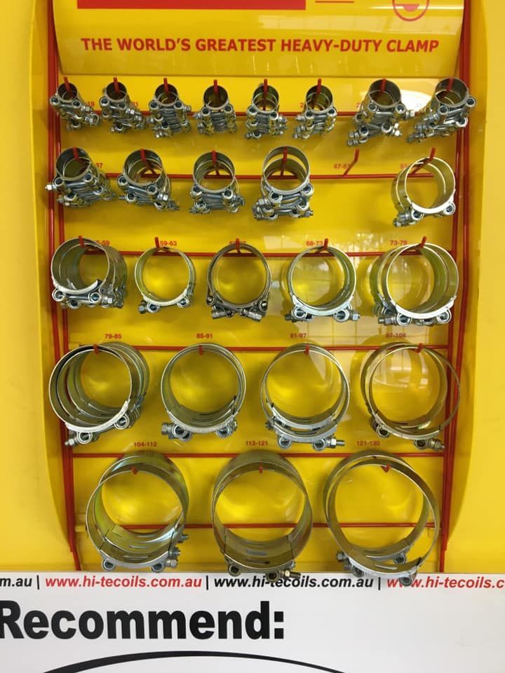 Display of heavy-duty hose clamps on a yellow retail board with product labels.