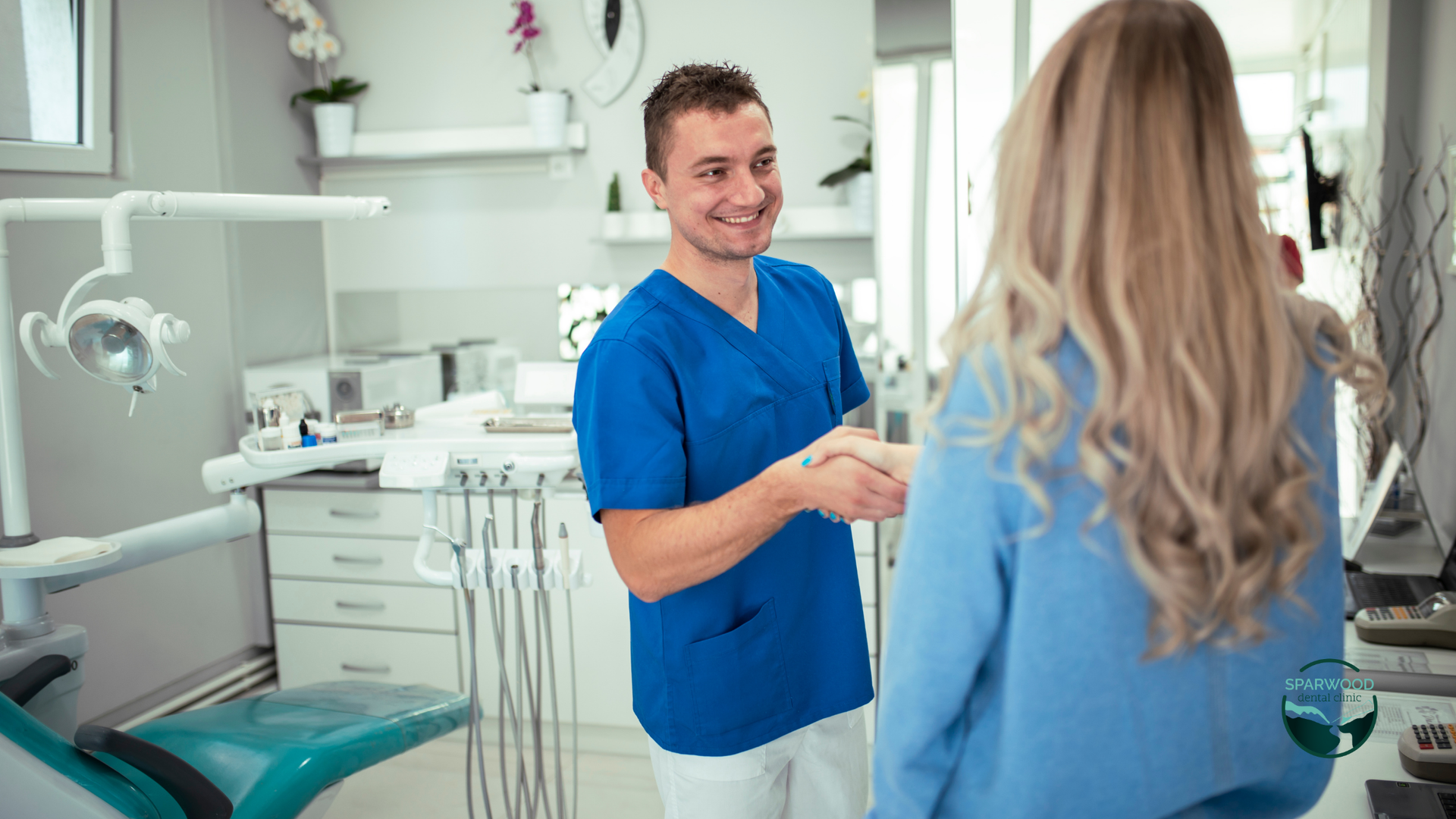 A dentist is shaking hands with a patient in a dental office.