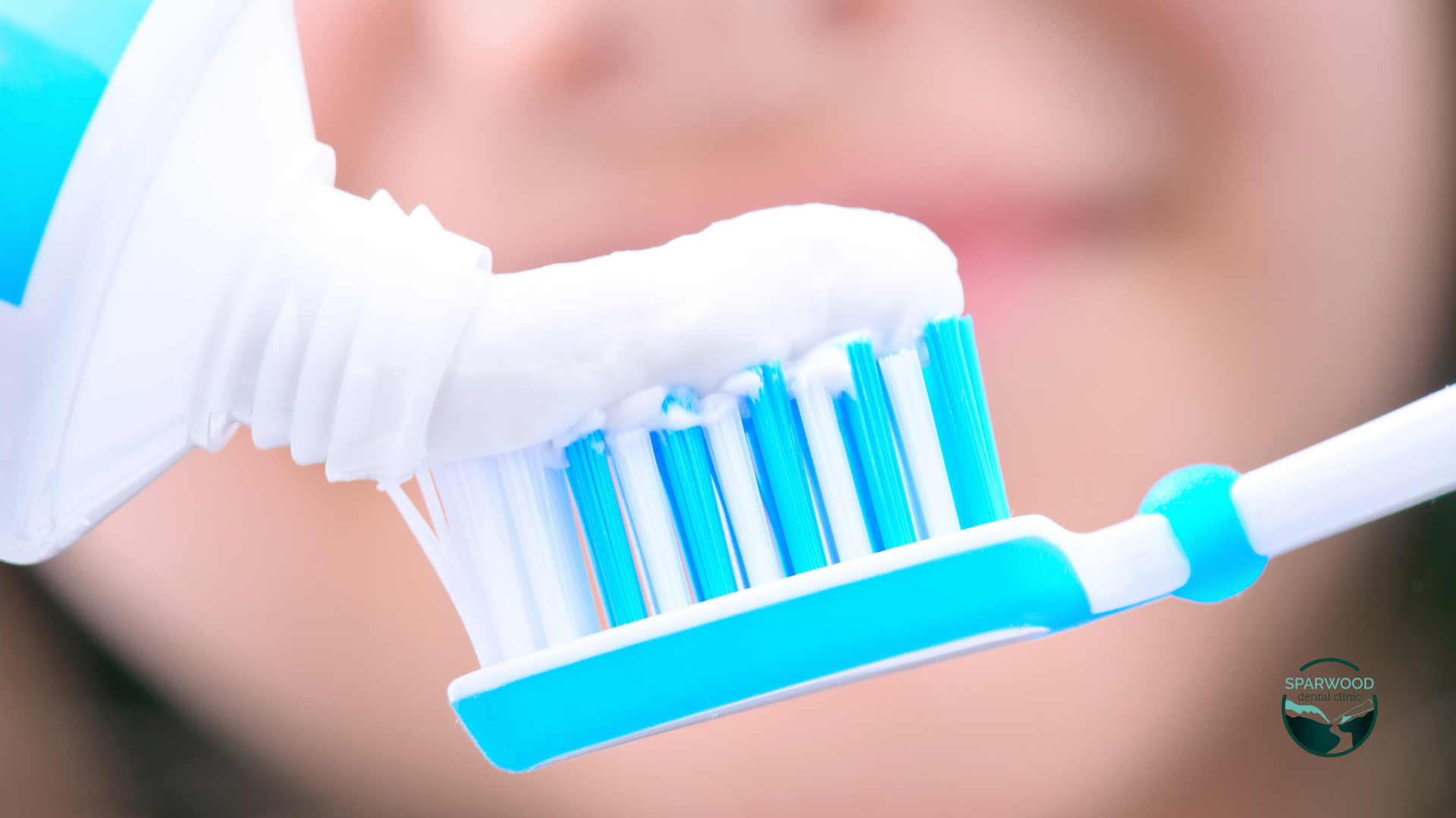 A person is applying toothpaste to a toothbrush.