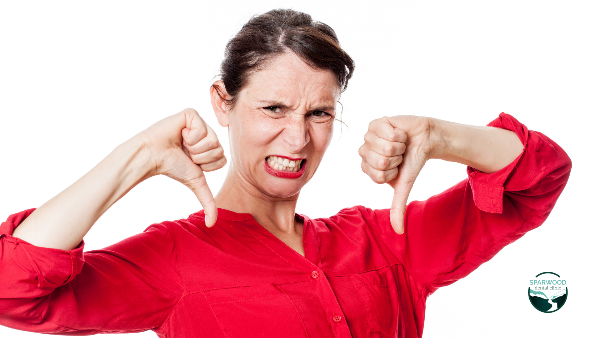 A woman in a red shirt is giving a thumbs down sign.