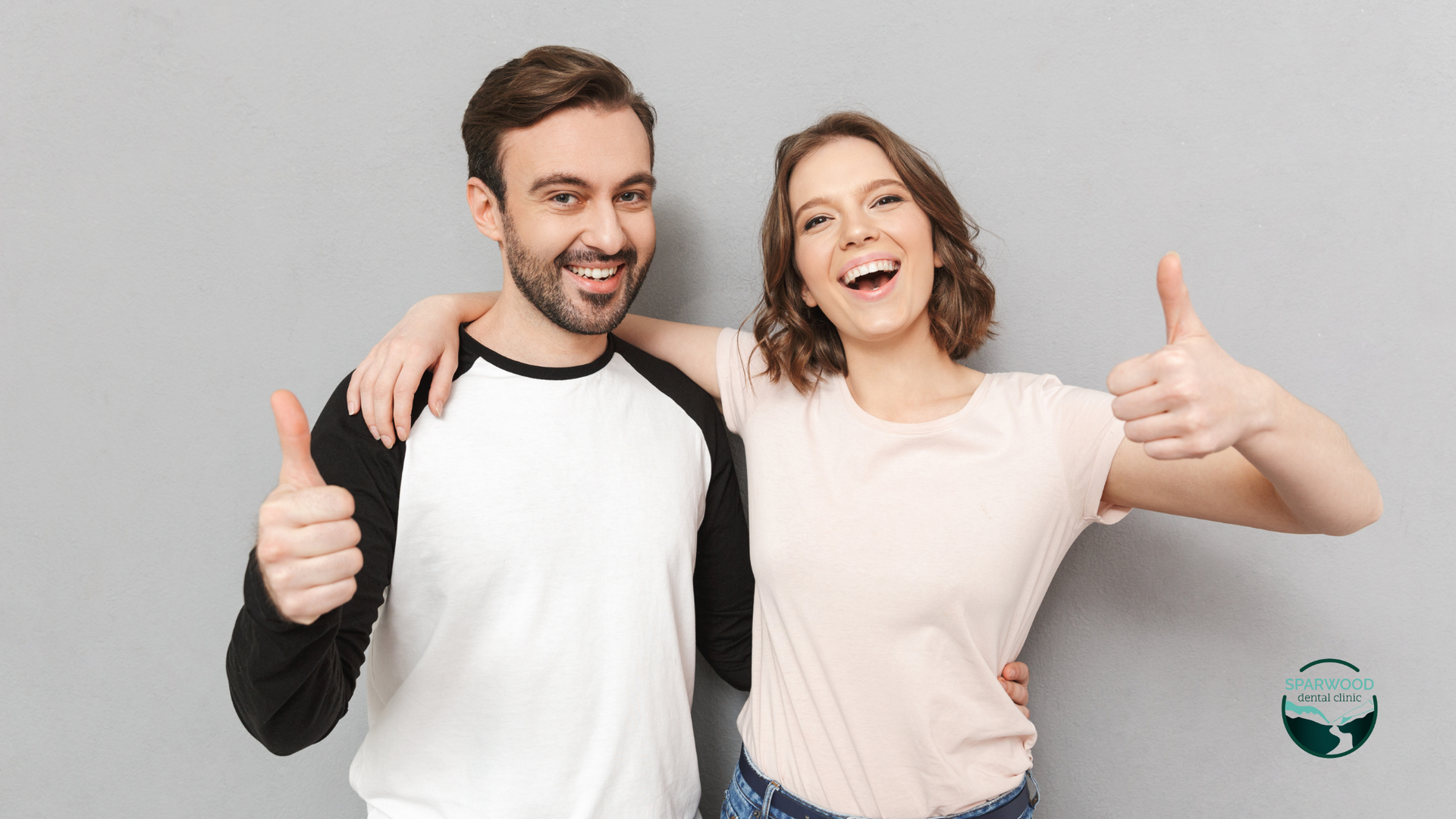 A man and a woman are standing next to each other and giving a thumbs up.