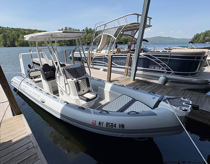 2023 Trophy T24CX with blue hull tied up at dock